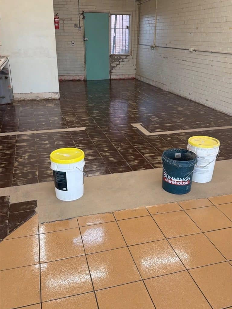 Sacrificial coat applied over existing tiled floor before epoxy flake flooring installation in Rosebud