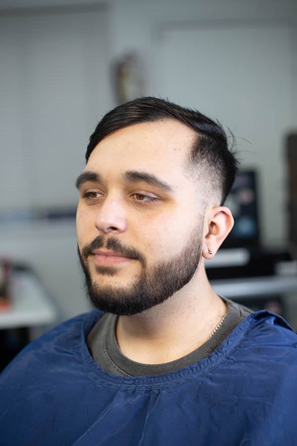 A man with a comb-over haircut with a beard lineup done at the barbershop in gardena ca 90247