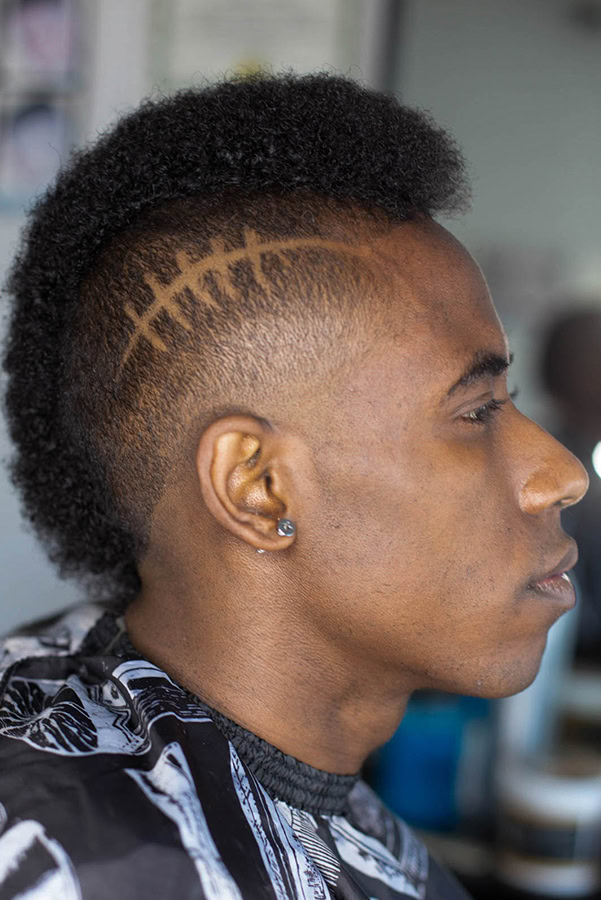 a man with tight curly hair rocking a mohawk with a design on the side of the head that was cut in gardena ca 90249