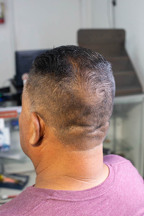 A back angle of a man with a short slickback haircut taht was cut in gardena ca 90249
