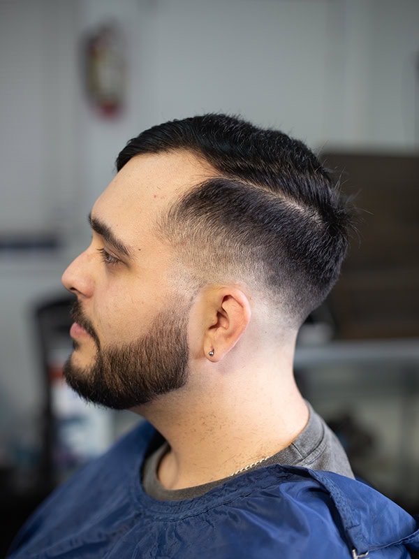 A man with a low fade at a barber shop in Gardena
