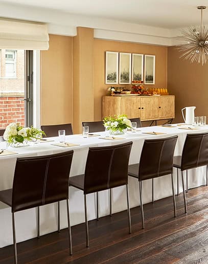 Stylish dining room with long table and modern decor.