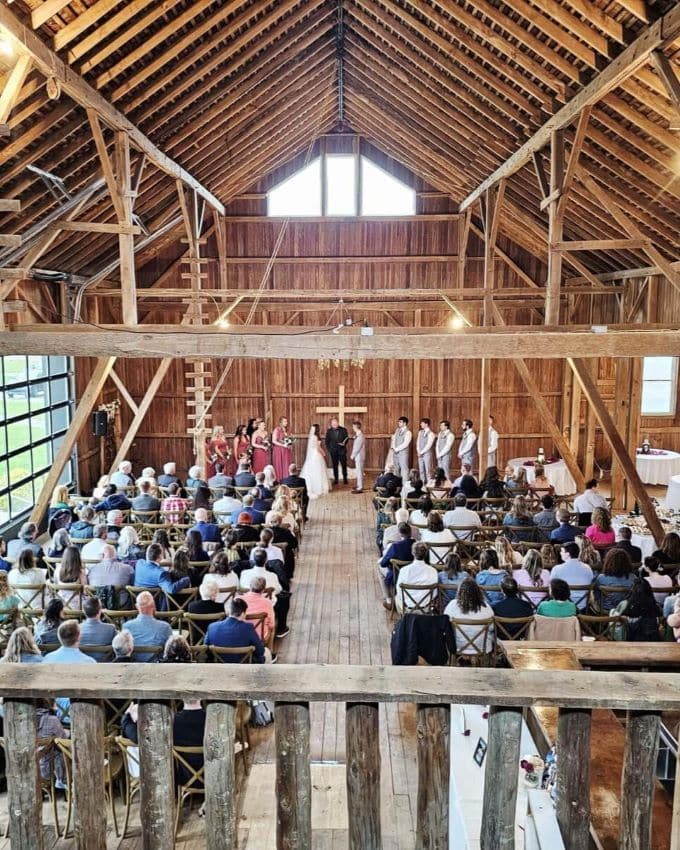 Vow renewal ceremony inside rustic Oak & Ivory Wedding & Event Center in Ashland, Ohio, featuring wooden architecture and a cross backdrop.