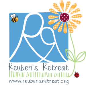 Logo of Reuben's Retreat featuring stylized white 'RR' initials on a sky-blue background with a bee on the top left and a cheerful daisy on the right. Below, the text reads 'Reuben's Retreat' above a field of green grass with a ladybug, and the website 'www.reubensretreat.org' is at the bottom. The color scheme is playful with a black border framing the design.
