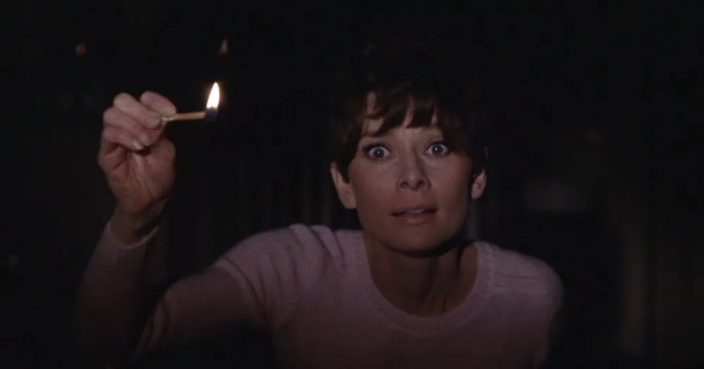 Audrey Hepburn holds up a match in the darkness in Wait Until Dark