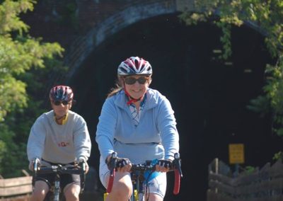 Cyclists enjoying a scenic trail ride near a tunnel.