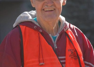 U.S. Army veteran wearing a cap and red vest outdoors.