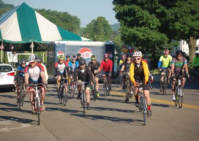 Group of cyclists riding on a city street during an event.