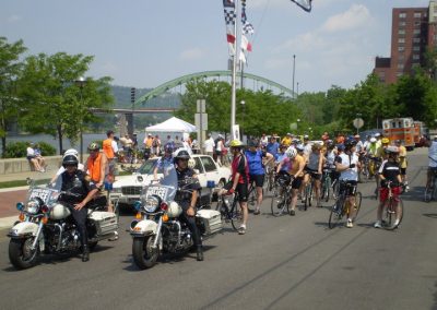 Cyclists and police officers at a community event in an urban park.