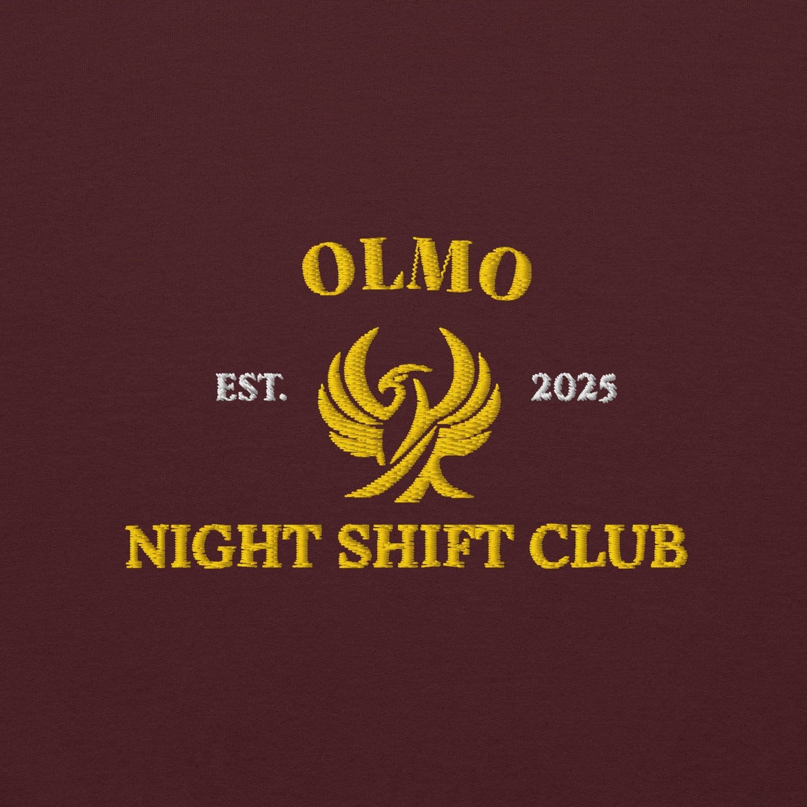 Logo brodé de style luxueux pour le Sweat à capuche Night Shift Club d'OLMO lux, symbolisant l'élégance et l'infini dans la mode.