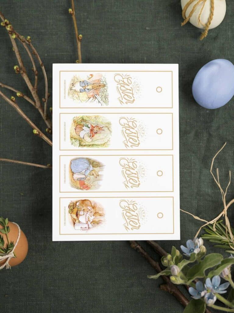 Free printable Easter bookmarks for kids with Peter Rabbit illustrations in bright pastel colors sitting on a branch with eggs.