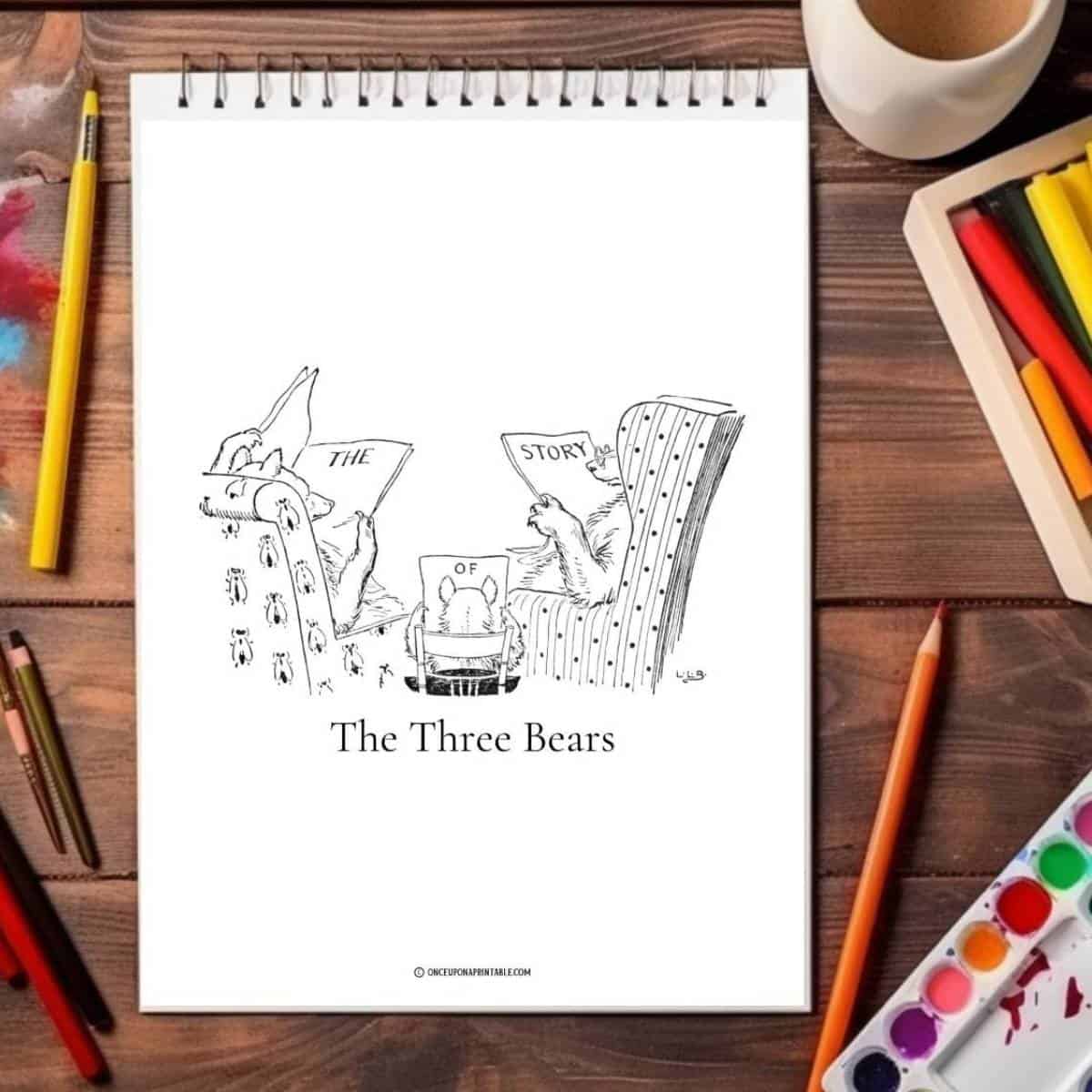 The three bears coloring pages on a wooden table with coloring pencils.