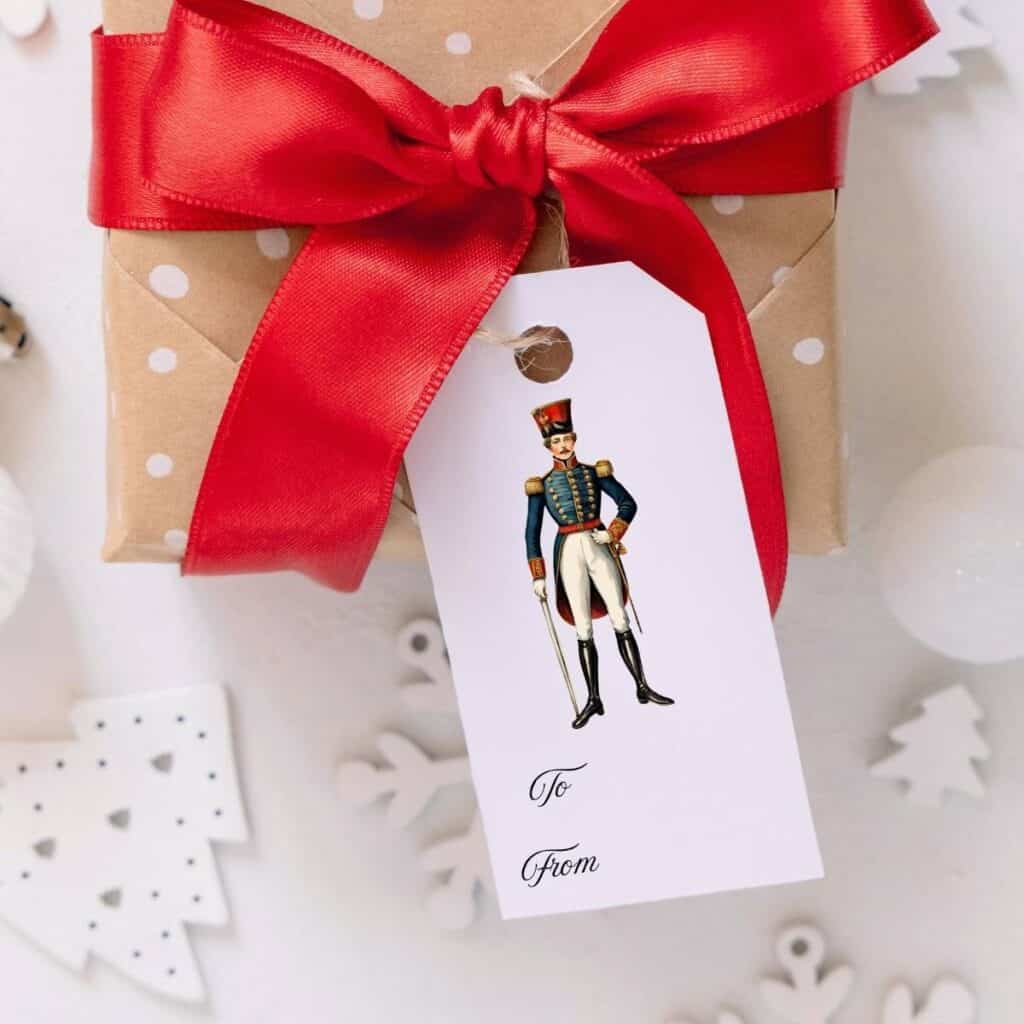 The nutcracker prince watercolor illustration gift tag on a package with a red blow.