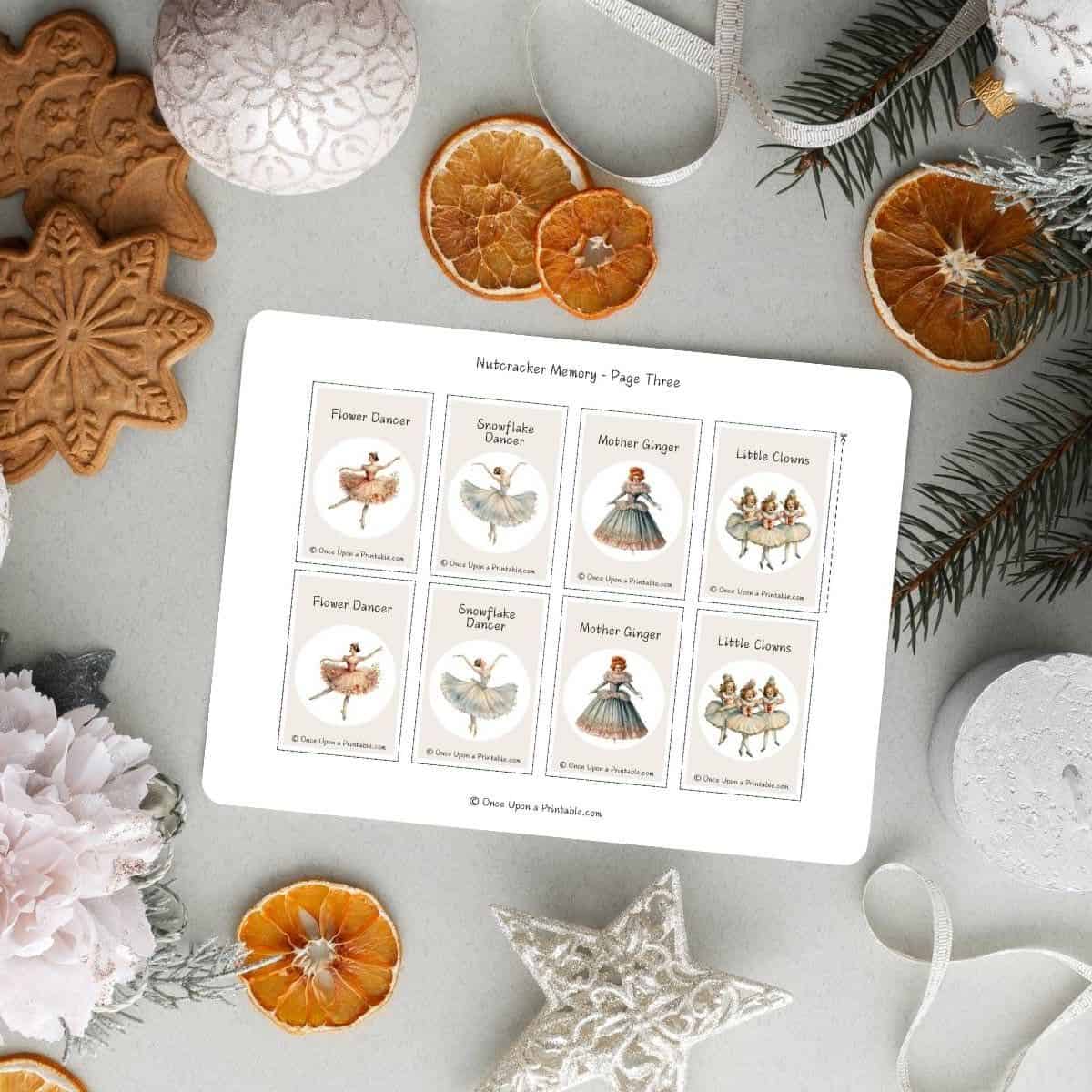 Nutcracker memory game cards on a printable, displayed with dried orange slices, gingerbread cookies, and flowers.