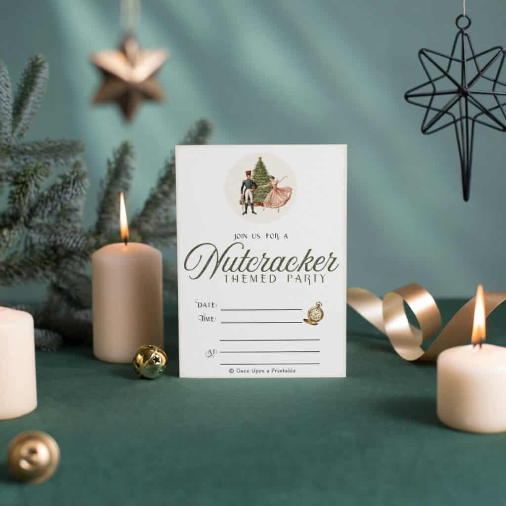 Nutcracker themed party invitations next to lit candles on green velvet and a christmas tree.