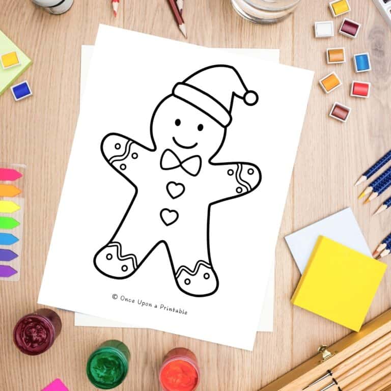 A gingerbread man santa claus coloring pages sitting next to coloring supplies like paints, pencils, etc.