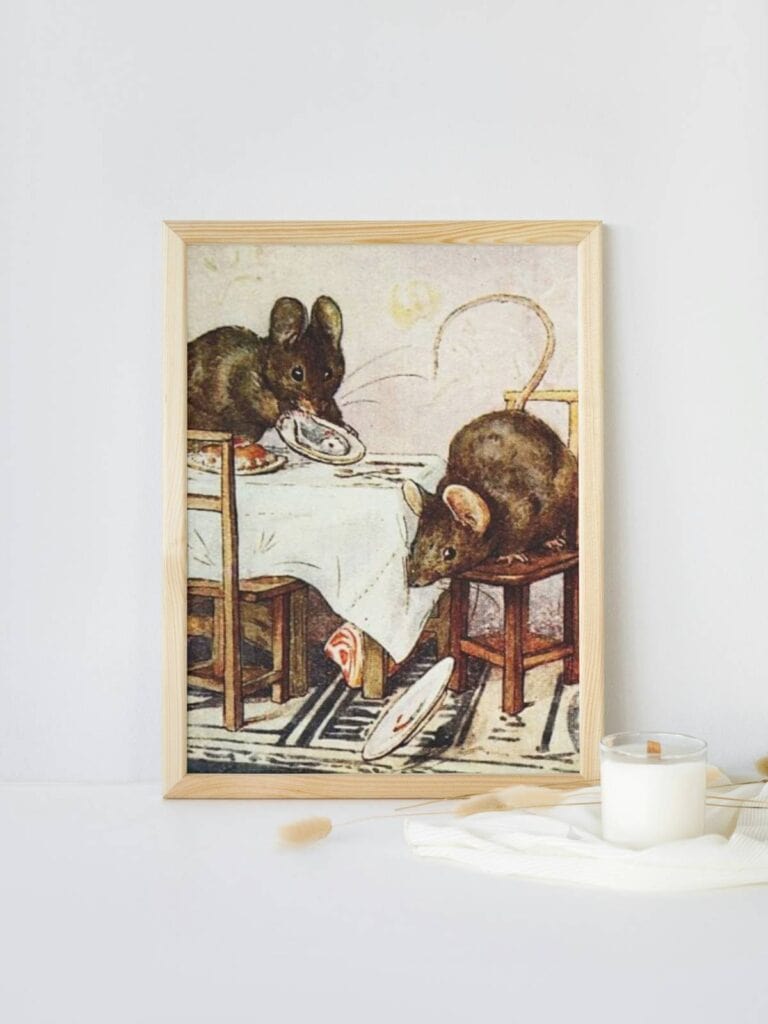 Two bad mice illustration framed and displayed on a white surface next to a candle.