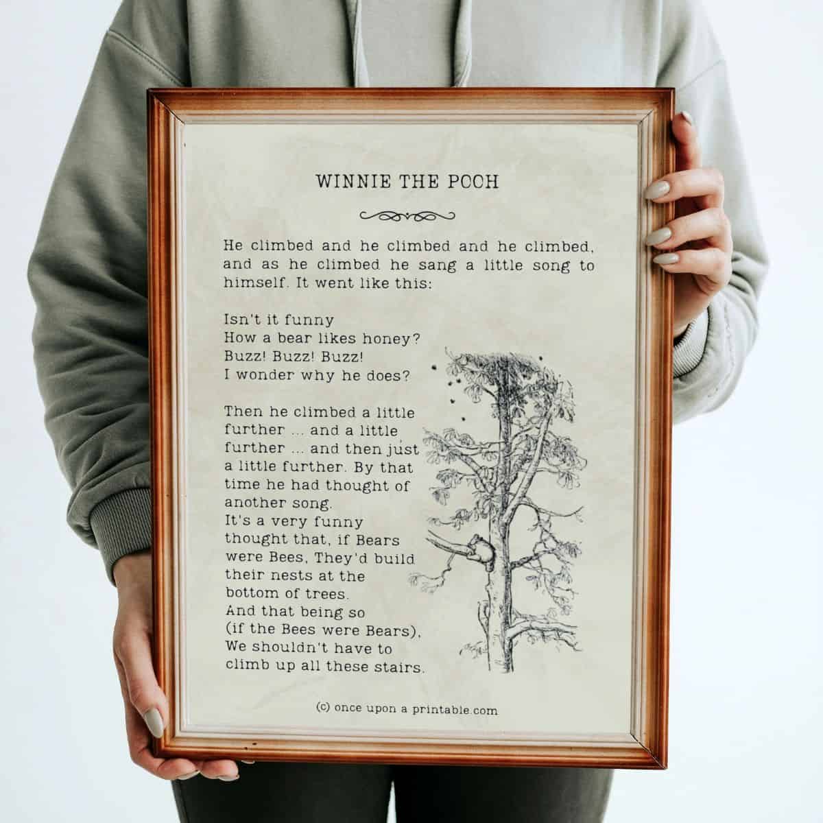 A winnie the pooh quotes by A A Milne with original illustration by E H Shepard framed and held in a woman's arms.