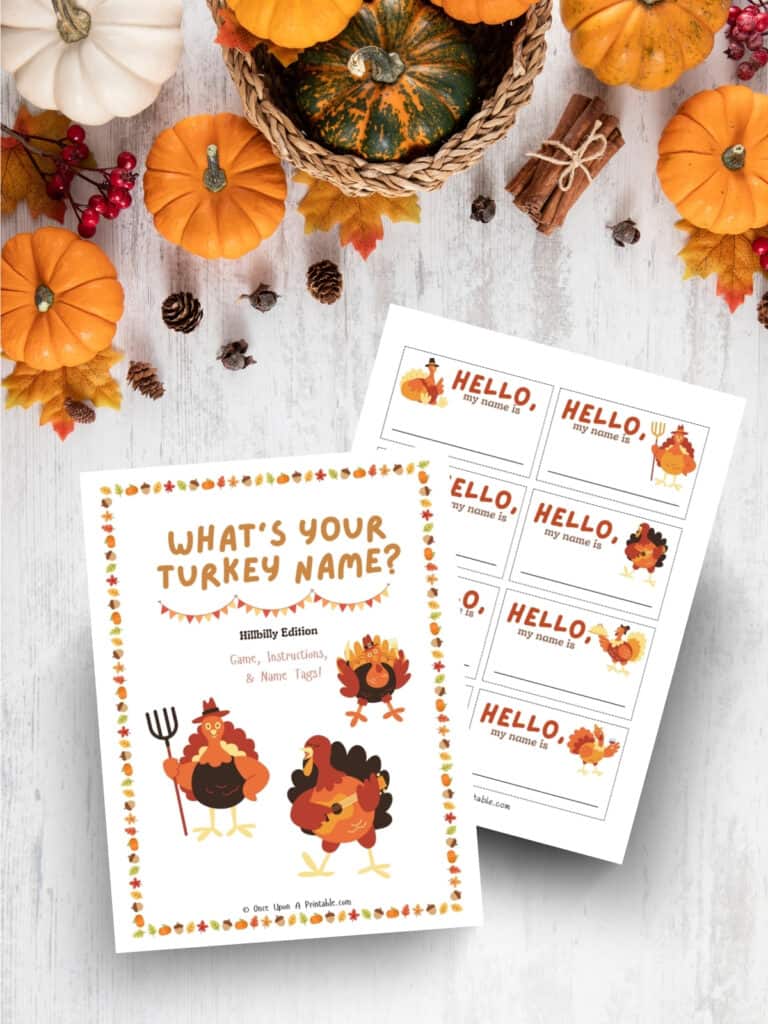 Thanksgiving "What's your turkey name" printables sitting on a wooden surface with pumpkins and cinnamon sticks.