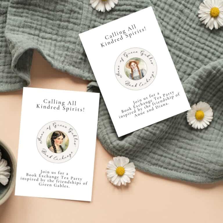 Anne and Diana book exchange invitations laying on a green blanket with daisies.