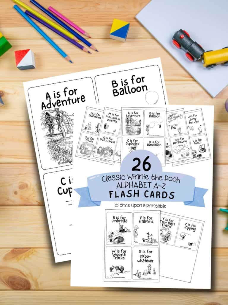 Classic Winnie the Pooh ABC flashcard printable laying on a wooden table with toys and coloring pencils.