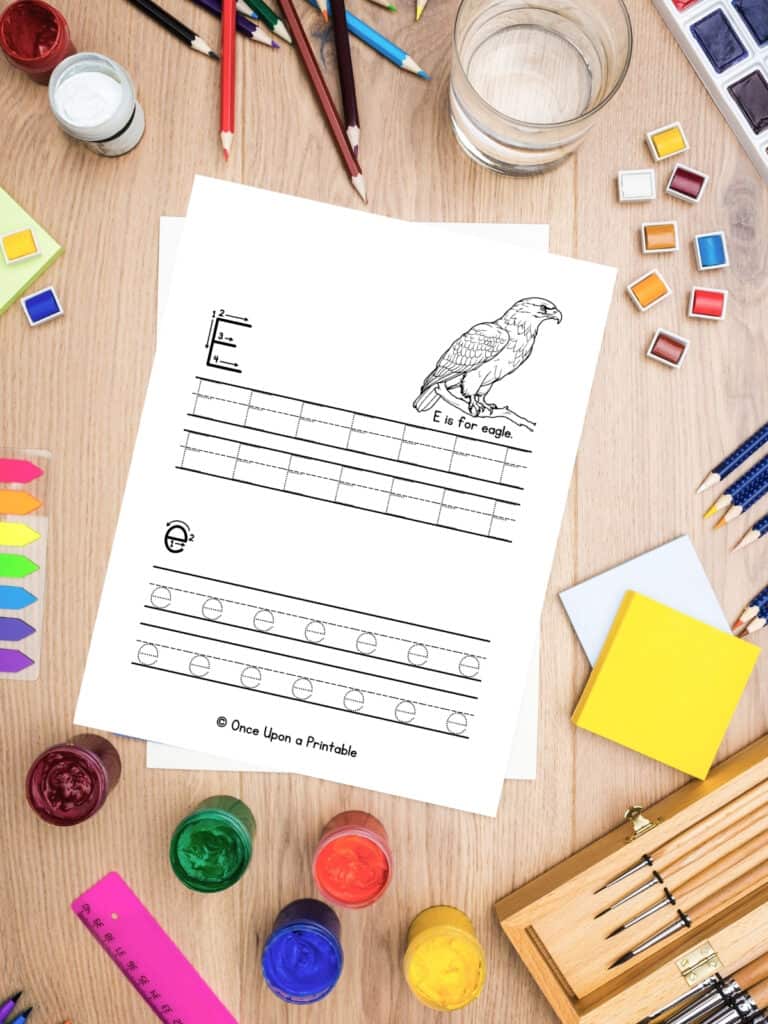 Letter E is for Eagle worksheets laying on the table with art supplies.