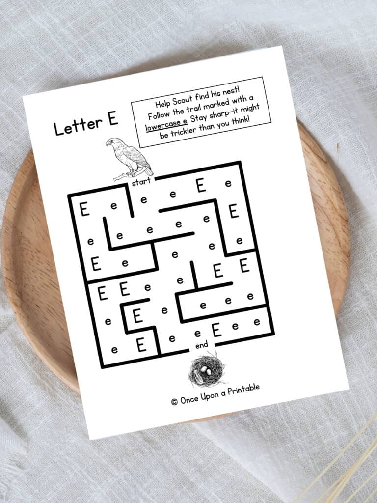 Letter E maze Eagle and nest worksheet laying on a wooden lazy Susan on a white tablecloth.