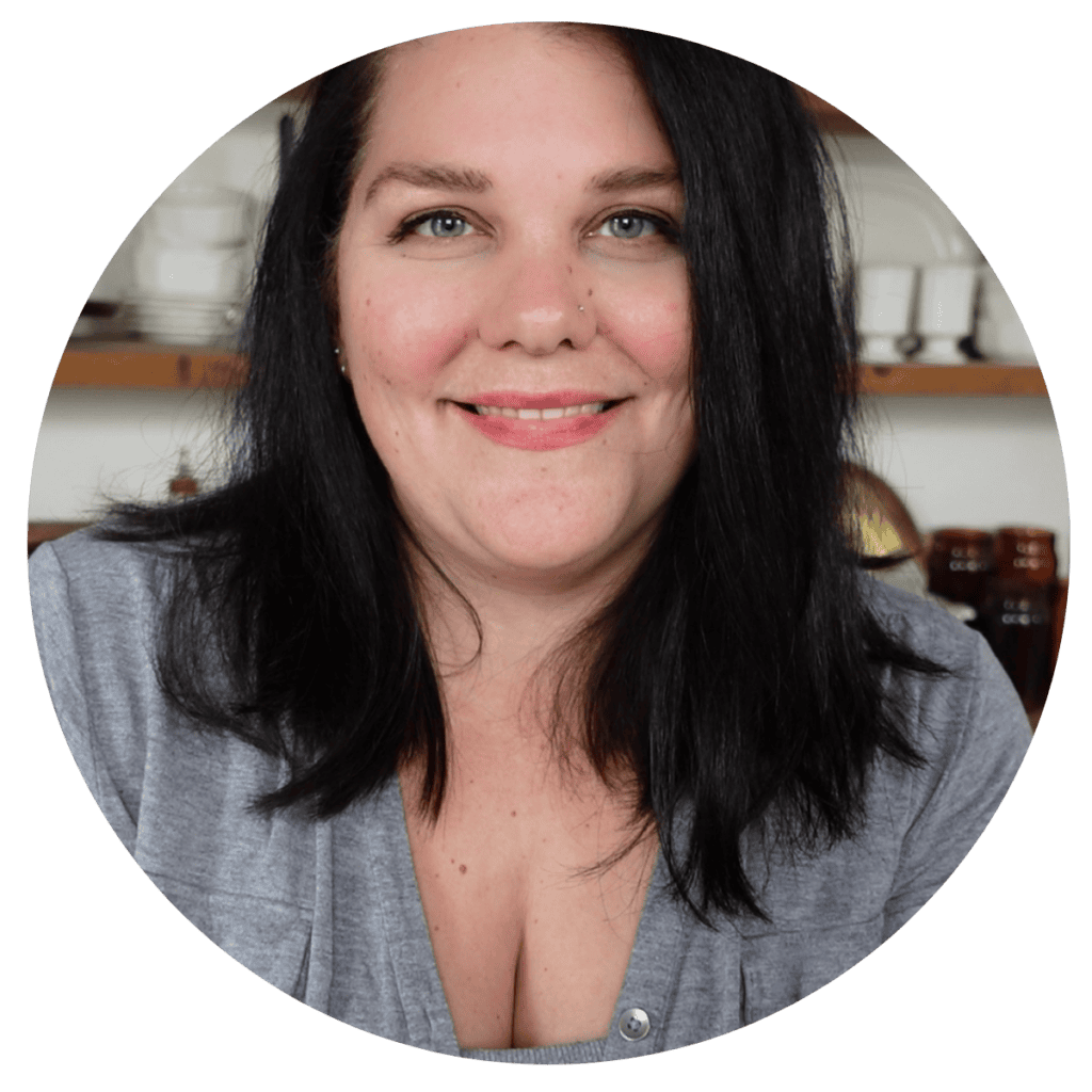 Julie Boston, owner and author a woman with dark shoulder length hair and a grey shirt on.