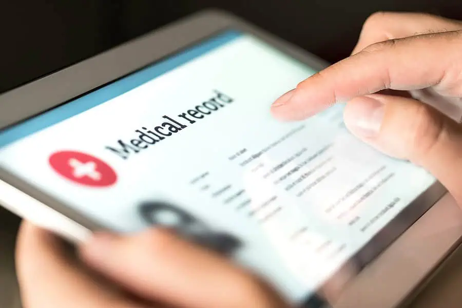 A person uses a tablet to view a screen displaying their digital medical record.