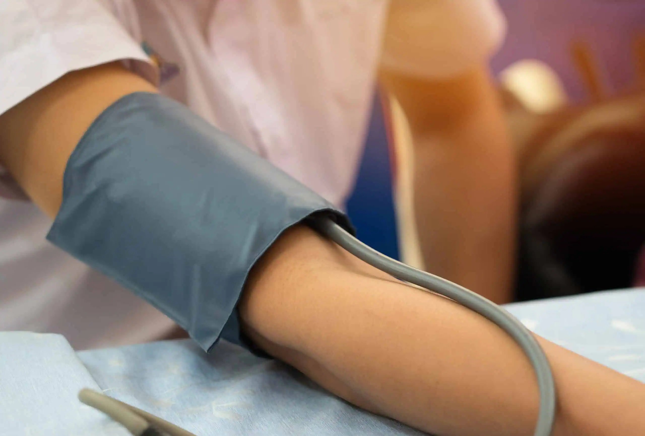 A person has their blood pressure measured with an arm cuff and monitor.