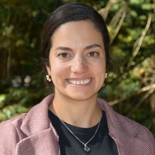 Smiling woman in front of trees