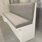 Hoge kwaliteit bankje met grijze bekleding en wit houten frame, perfect voor modern interieur.