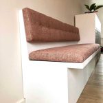 Sarek eetbank met roze bekleding en stoffen kussens, modern interieur.