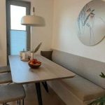 Moderne eetkamer met minimalistisch design en natuurlijke kleuren.