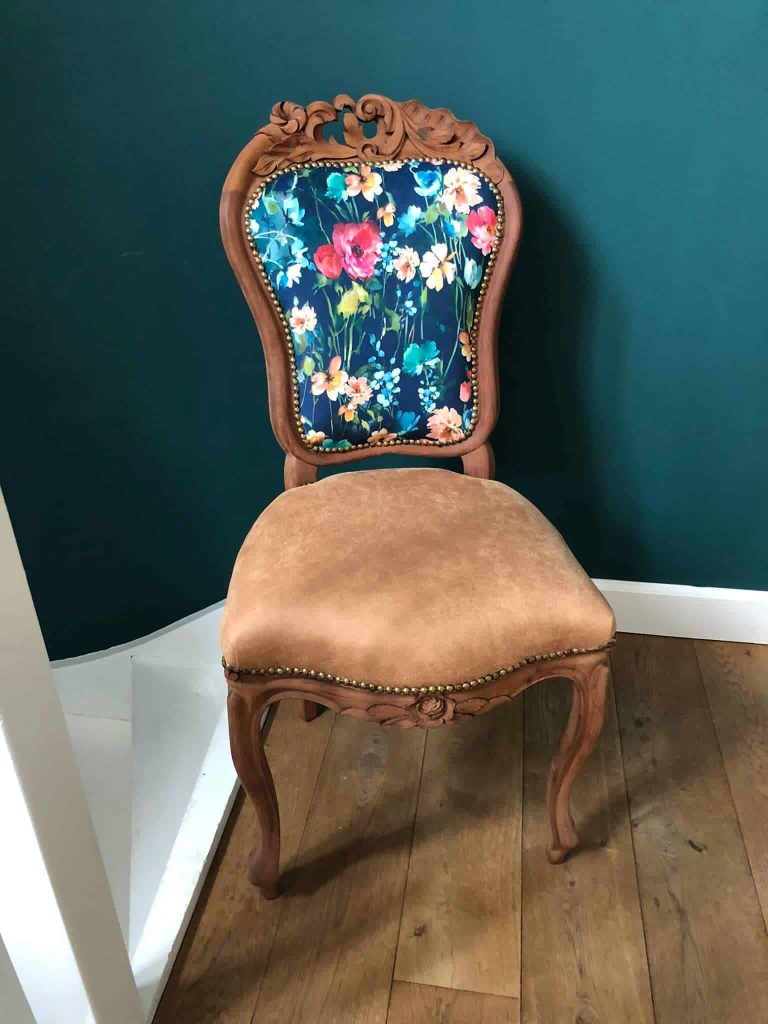 Een elegante houten vintage stoel met bloemmotief, perfect voor klassiek interieurdesign.