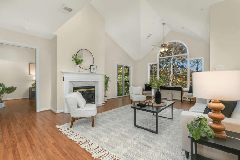 Bright and airy living room in a luxury Pleasanton, CA home featuring vaulted ceilings, large windows with scenic views, modern decor, and a cozy fireplace for elegant family gatherings.