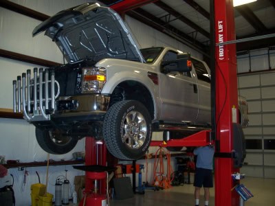 All Car & Truck Repair vehicle on lift with open hood at Outer Banks Tire.