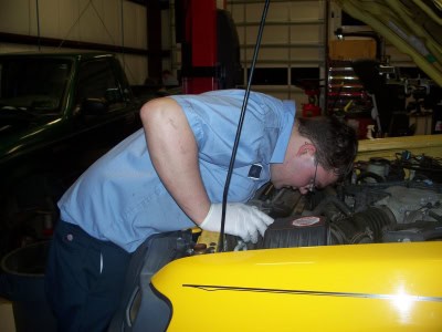 Skilled mechanic inspecting a car engine at Outer Banks Tire.