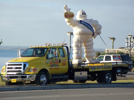 Michelin Man mascot on parade float during Outer Banks event.