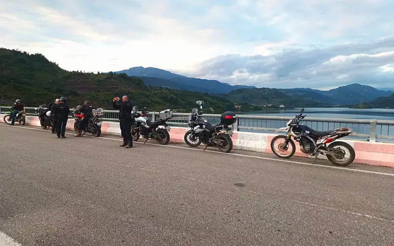 Group of motorcyclists enjoying a scenic ride along a lake in North Vietnam.