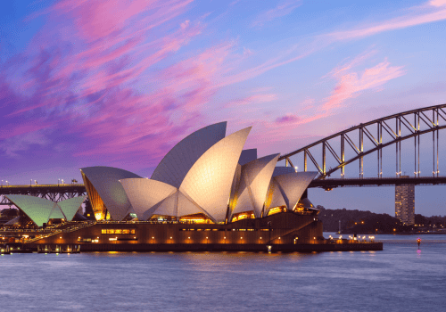 Sydney Opera House illuminated at sunset, with Sydney Harbour Bridge in the background, representing Ozora Electrical Services' location in Sydney.