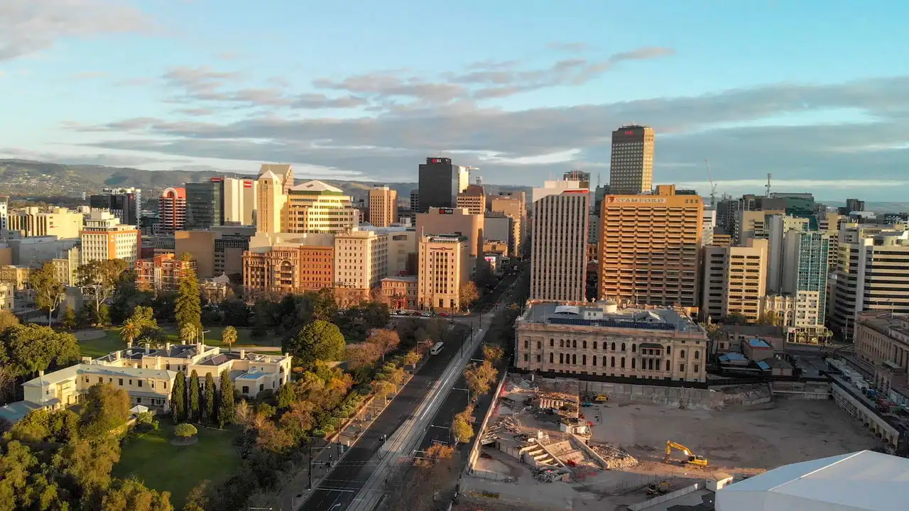 Adelaide city skyline featuring modern buildings, greenery, and construction sites, representing the urban landscape relevant to electrical services offered by Ozora.
