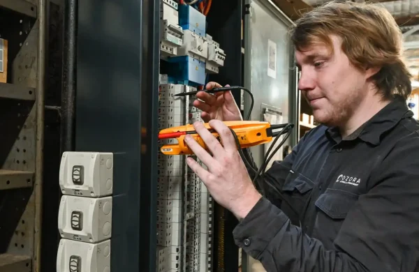 Electrician from Ozora using a multimeter to troubleshoot electrical panel, demonstrating expertise in commercial electrical services for Mildura facilities.