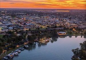 Aerial view of Mildura at sunset, showcasing the cityscape, waterfront, and boats, highlighting Ozora's electrical services presence in the area.