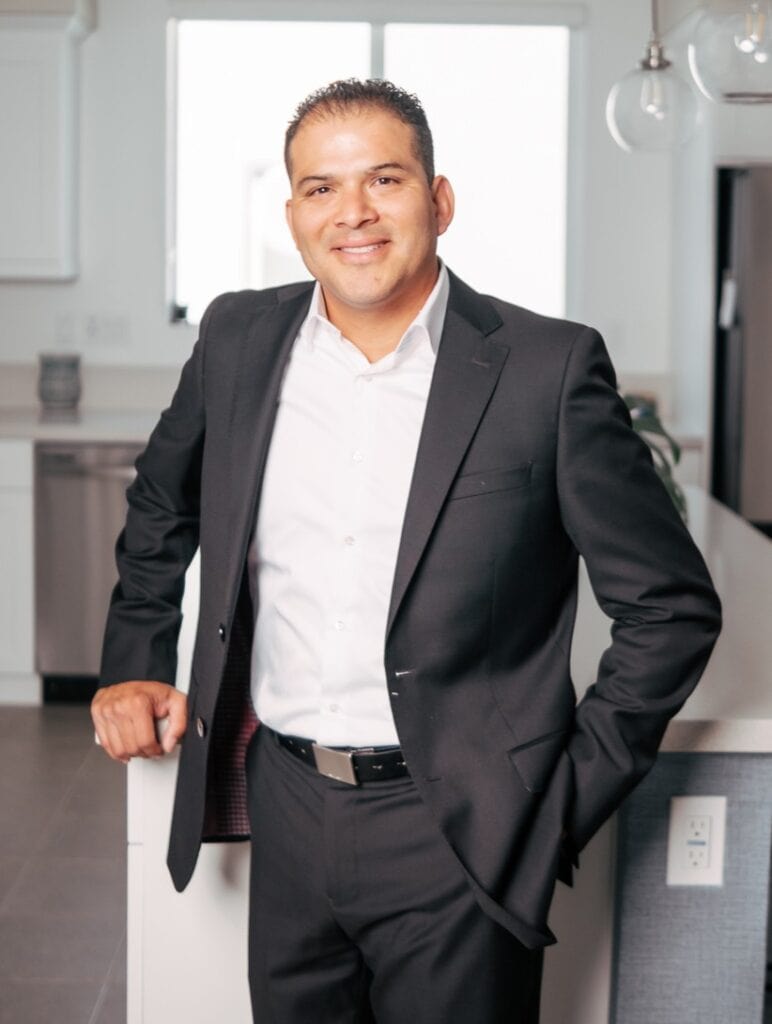 Professional male real estate agent in a modern kitchen setting.