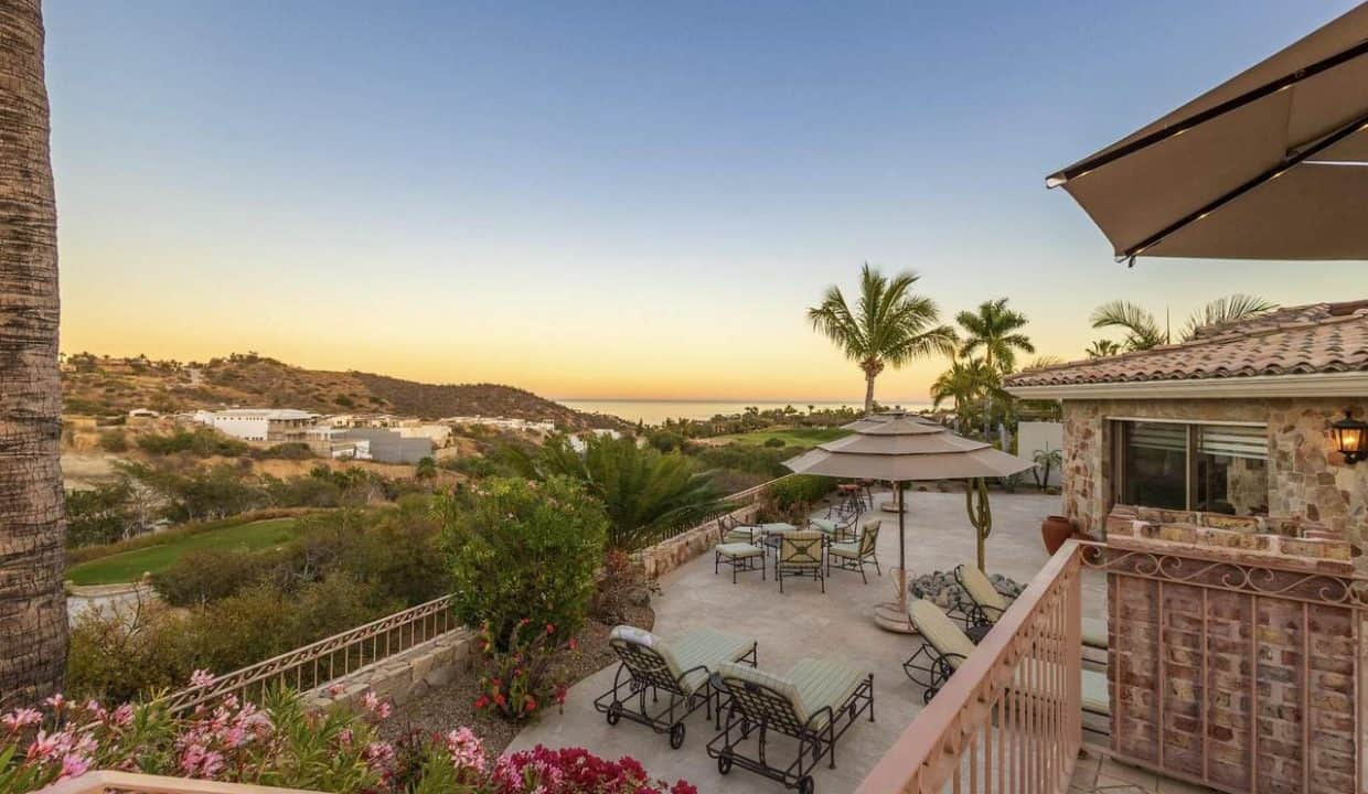 Luxury Palmilla Property Overlooking Sunset Views, With A Spacious Outdoor Patio Featuring Seating, Umbrellas, And Vibrant Flower Bushes, Perfect For Relaxing And Entertaining.