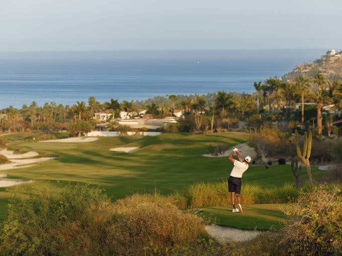 Golfer Taking A Tee Shot At Palmilla Golf Course Los Cabos With Ocean Views And Desert Landscape.