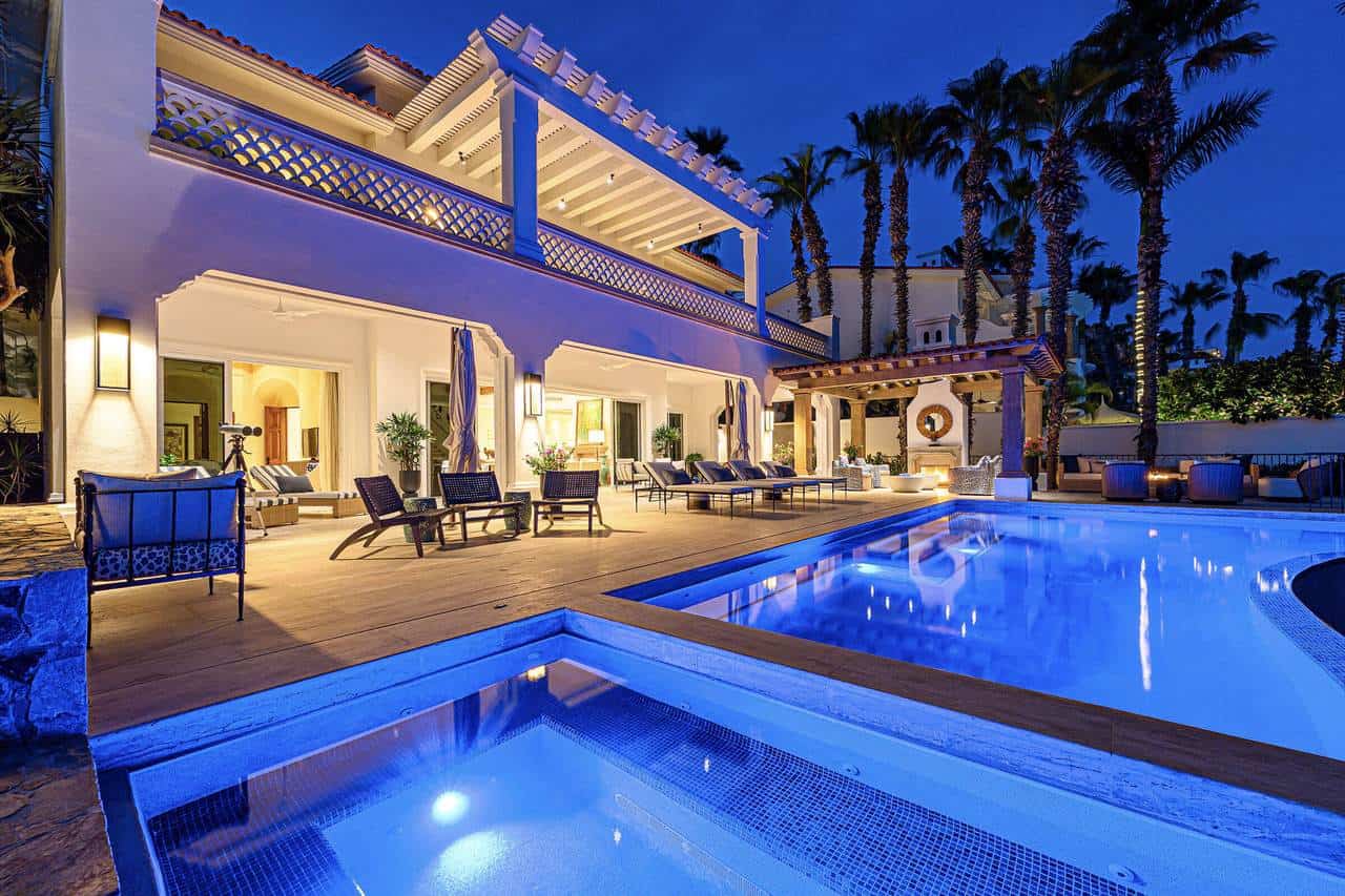 Palmilla Luxury Villa With Illuminated Pool And Tropical Palm Trees At Dusk.