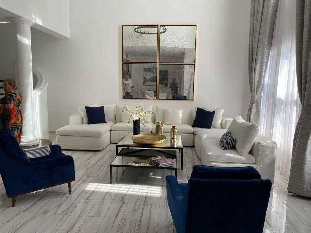 Palmilla Luxury Living Room With White Sofa And Navy Accent Chairs, Bright Natural Light, And Elegant Decor, Showcasing The Upscale Lifestyle In Palmilla.