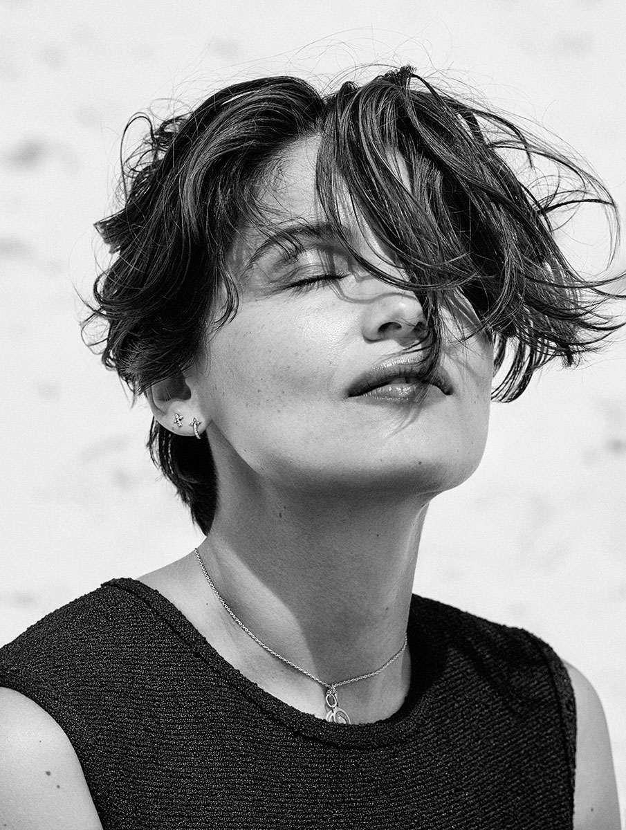 Elegant black and white portrait of a woman with tousled short hair, showcasing fine jewelry, intimate fashion photography by Pamela Hanson, emphasizing sophisticated style and glamorous artistry.